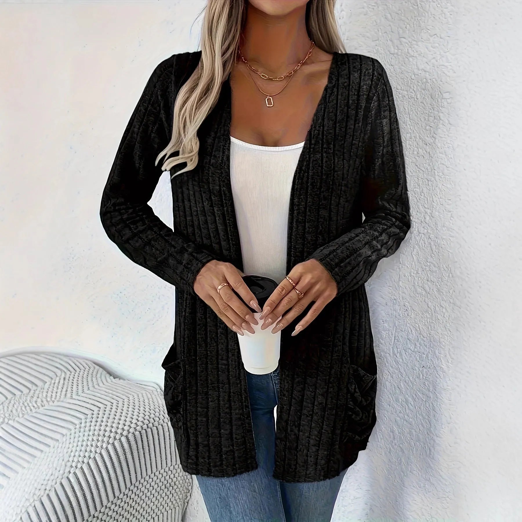 A person wearing a solid grey loose fit long sleeve cardigan with a chest pocket.