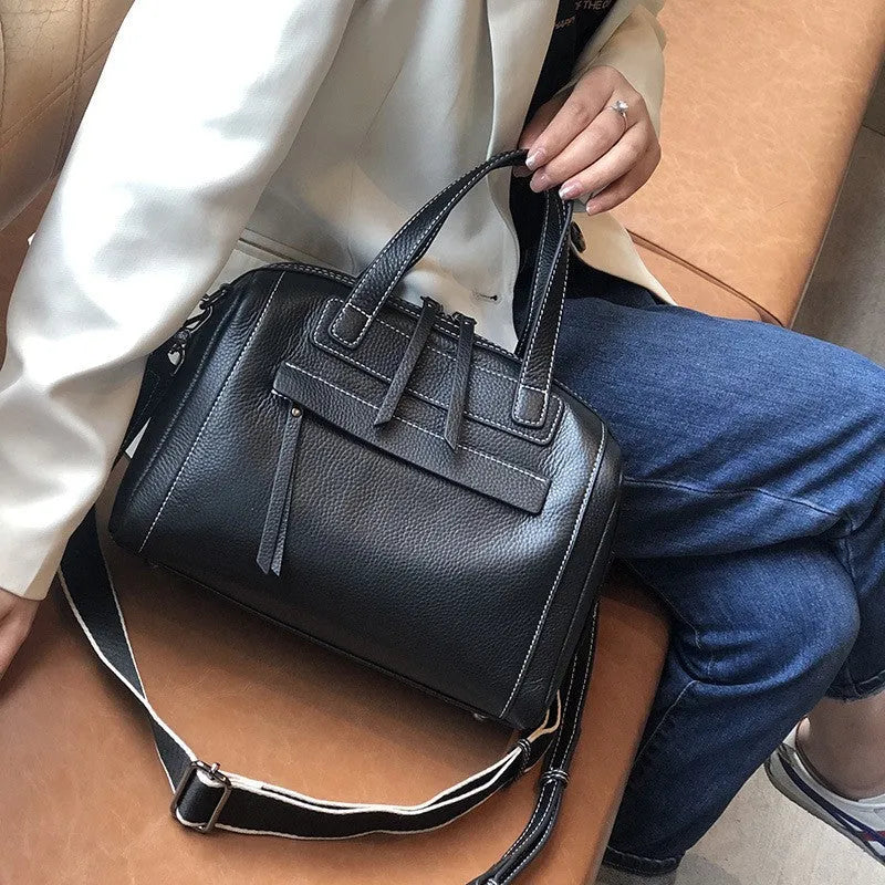 Soft black cowhide leather messenger bag with lychee pattern, showing internal phone and camera pockets.