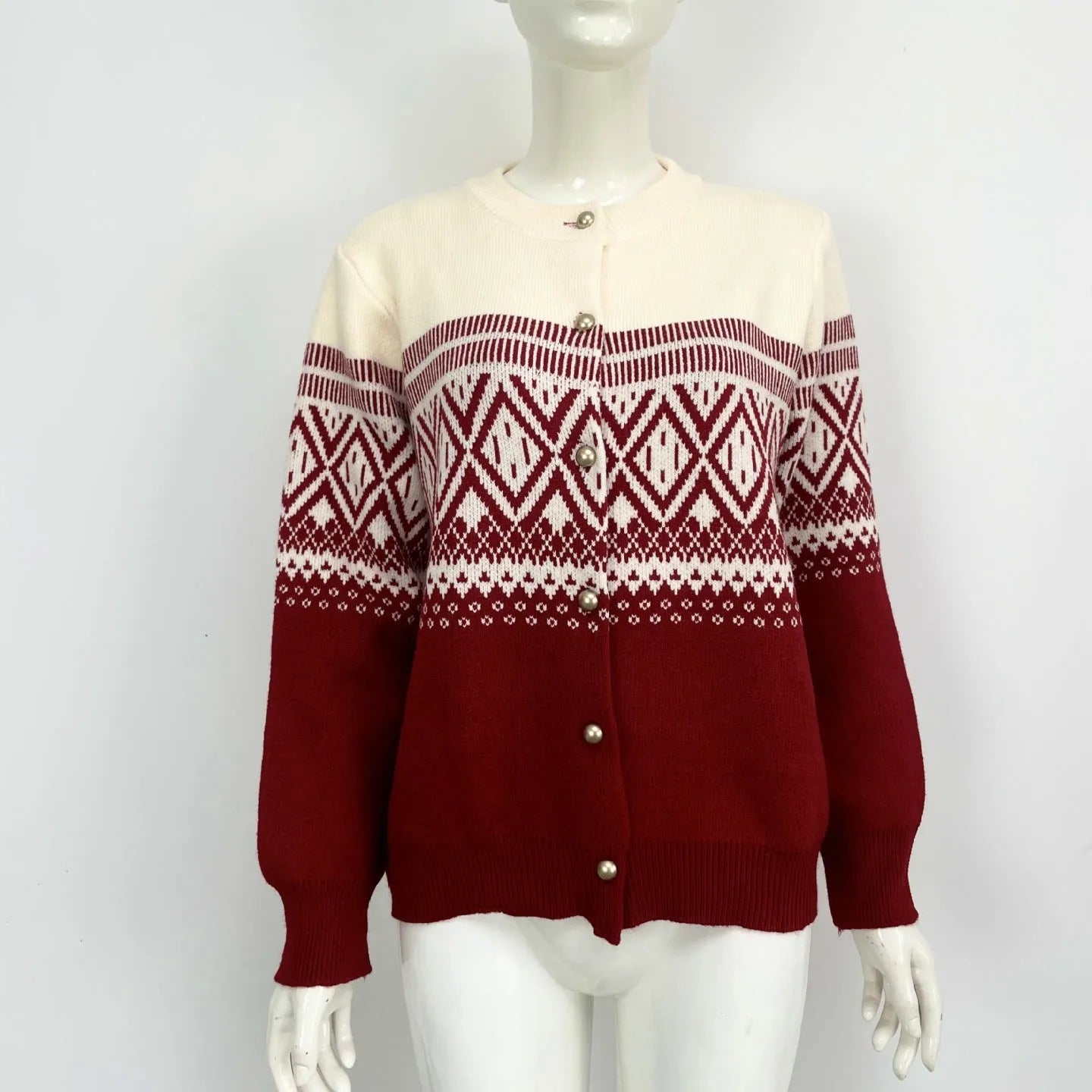 Woman wearing a red alpaca wool cardigan with a diamond knit pattern and long sleeves.