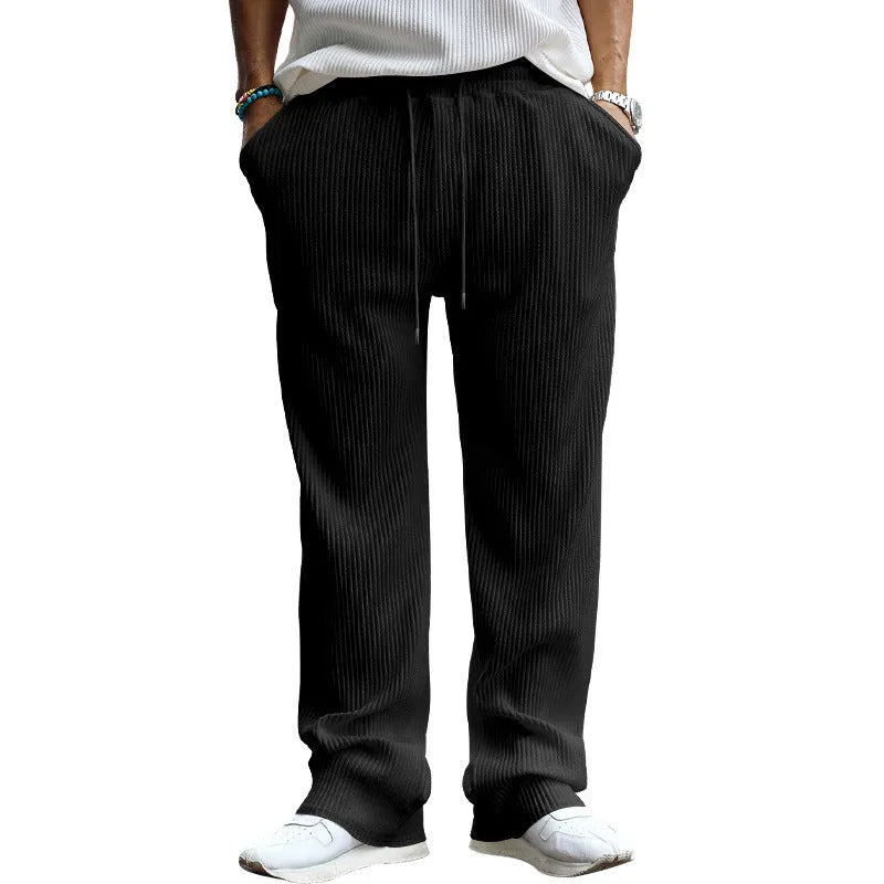 Man wearing loose high-waisted straight-leg casual trousers in army green.