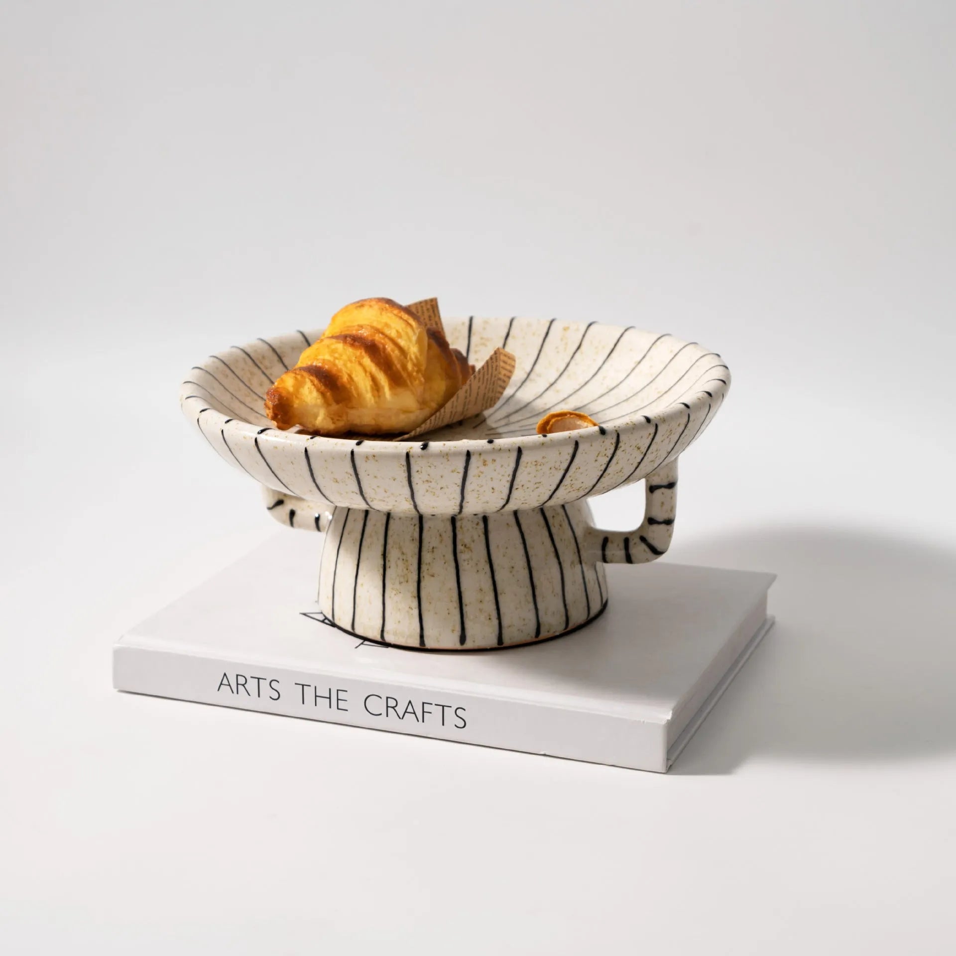 Black and white striped plastic resin fruit plate on a wooden surface.