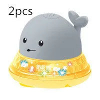 Whale-shaped baby bath toy with automatic water spray and colourful lights floating in water.