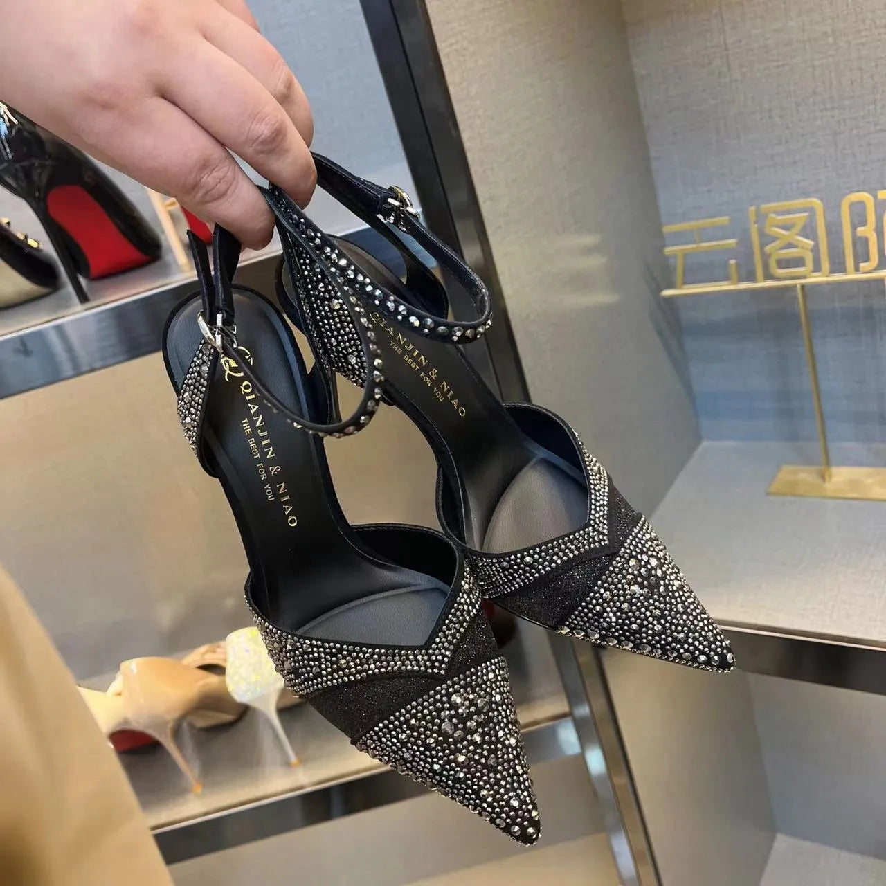 Women's black and silver hollow high heels with red sole and stiletto heel design