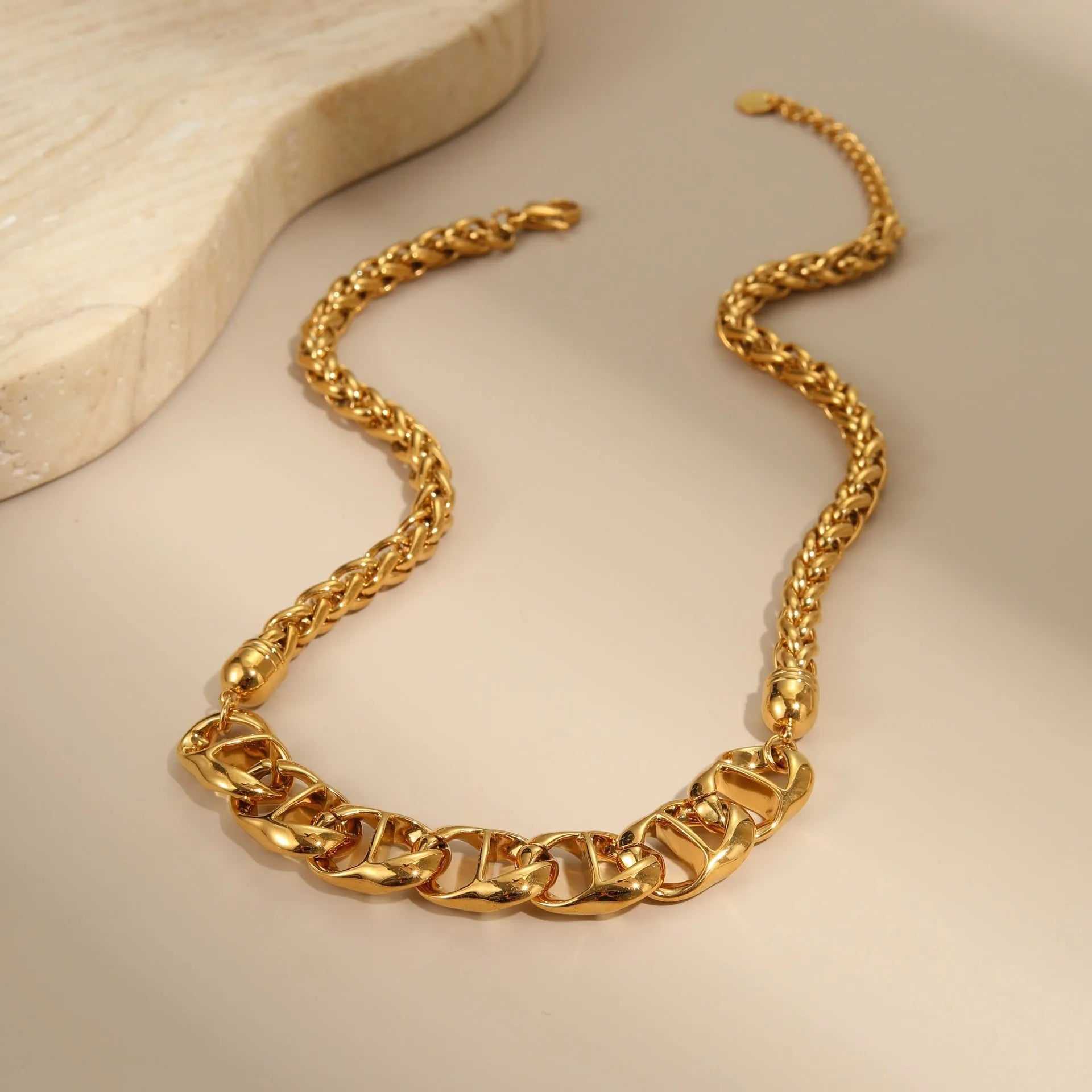 Stainless steel geometric pendant necklace with gold plating on a regular chain.