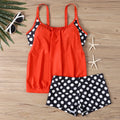 Women's black polka dot high-waist swimsuit briefs and top on a mannequin