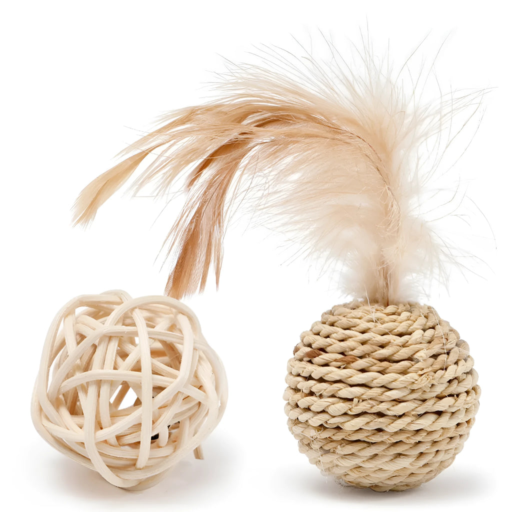 Two cat toys: hollow rattan ball and faux feather ball with bell on wooden floor