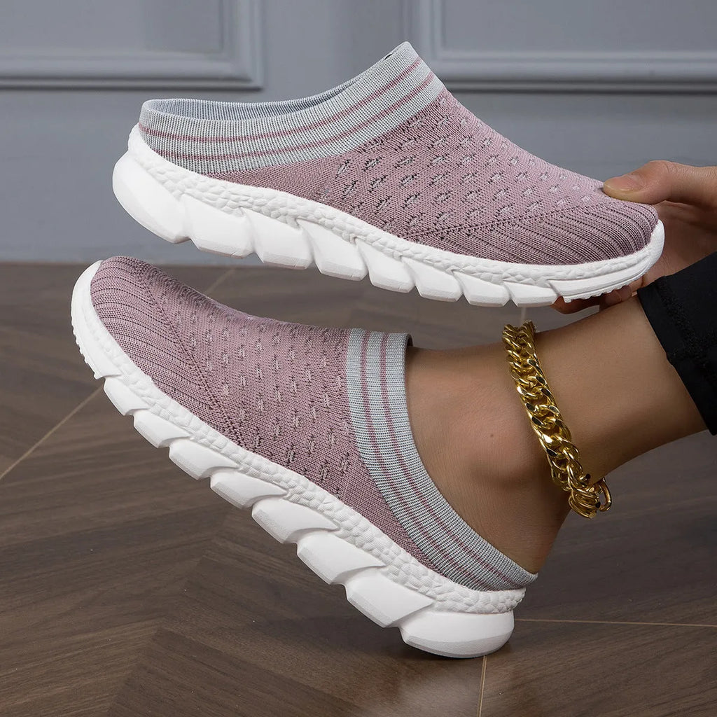 Black women's Flyknit sports slipper with hollowed-out pattern and striped design on a light background.