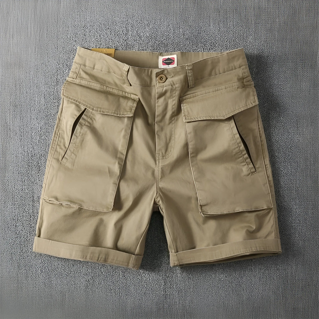 Men's straight-leg cotton cargo shorts in khaki with multiple pockets, shown on a model.