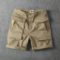 Men's straight-leg cotton cargo shorts in khaki with multiple pockets, shown on a model.