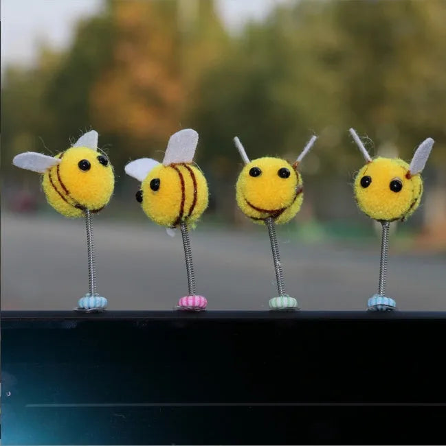 Small yellow and black fur ball bee car ornament with adhesive backing.
