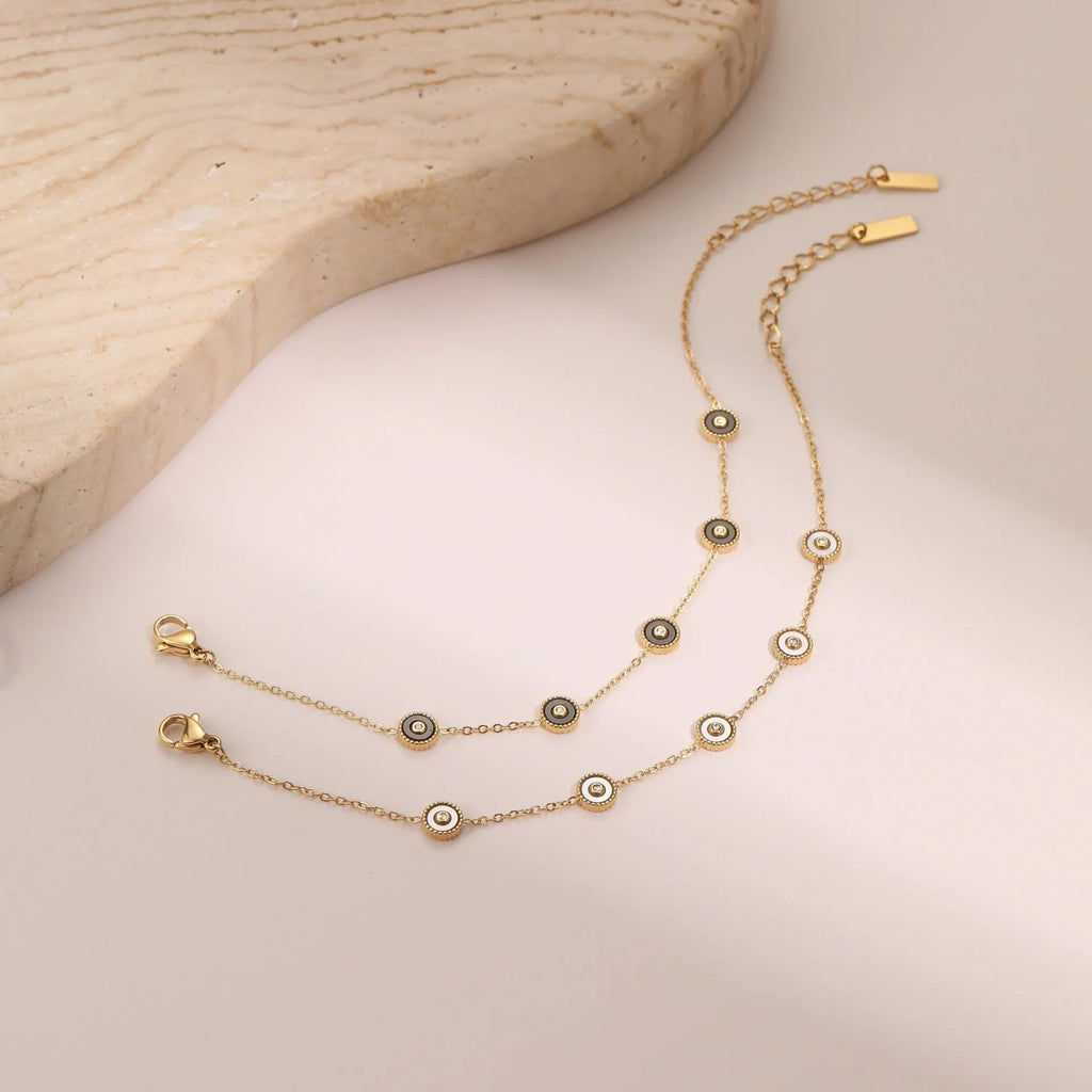 Women's stainless steel bracelet and necklace set with 18K gold plating and geometric design.
