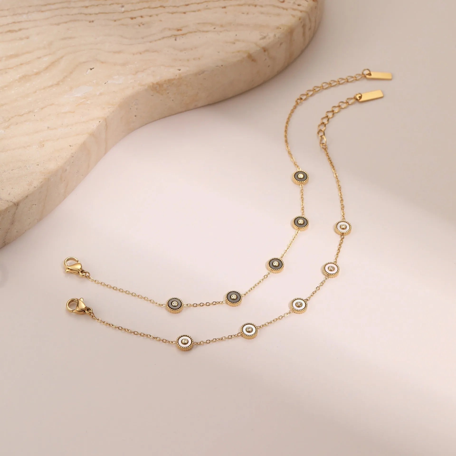Women's stainless steel bracelet and necklace set with 18K gold plating and geometric design.