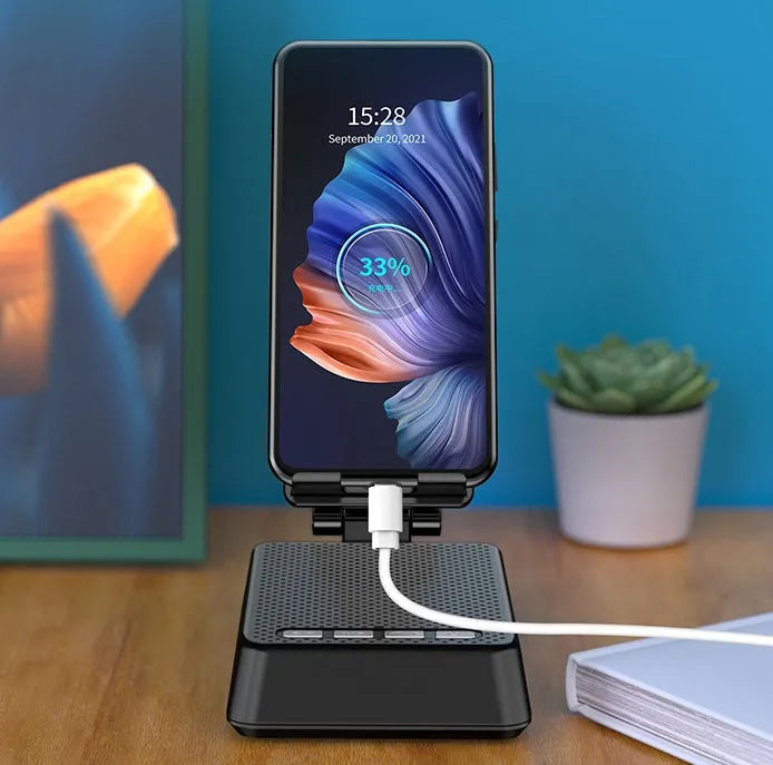 Black mobile phone broadcaster stand with wireless Bluetooth speaker and integrated HD microphone on desk