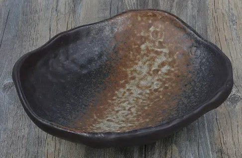Creative Japanese ceramic sashimi bowl with irregular shape and floral decoration on table