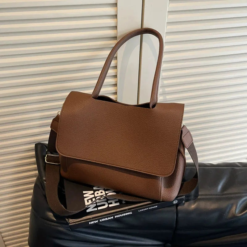 A brown PU tote bag with double shoulder straps and visible sewing thread detail.