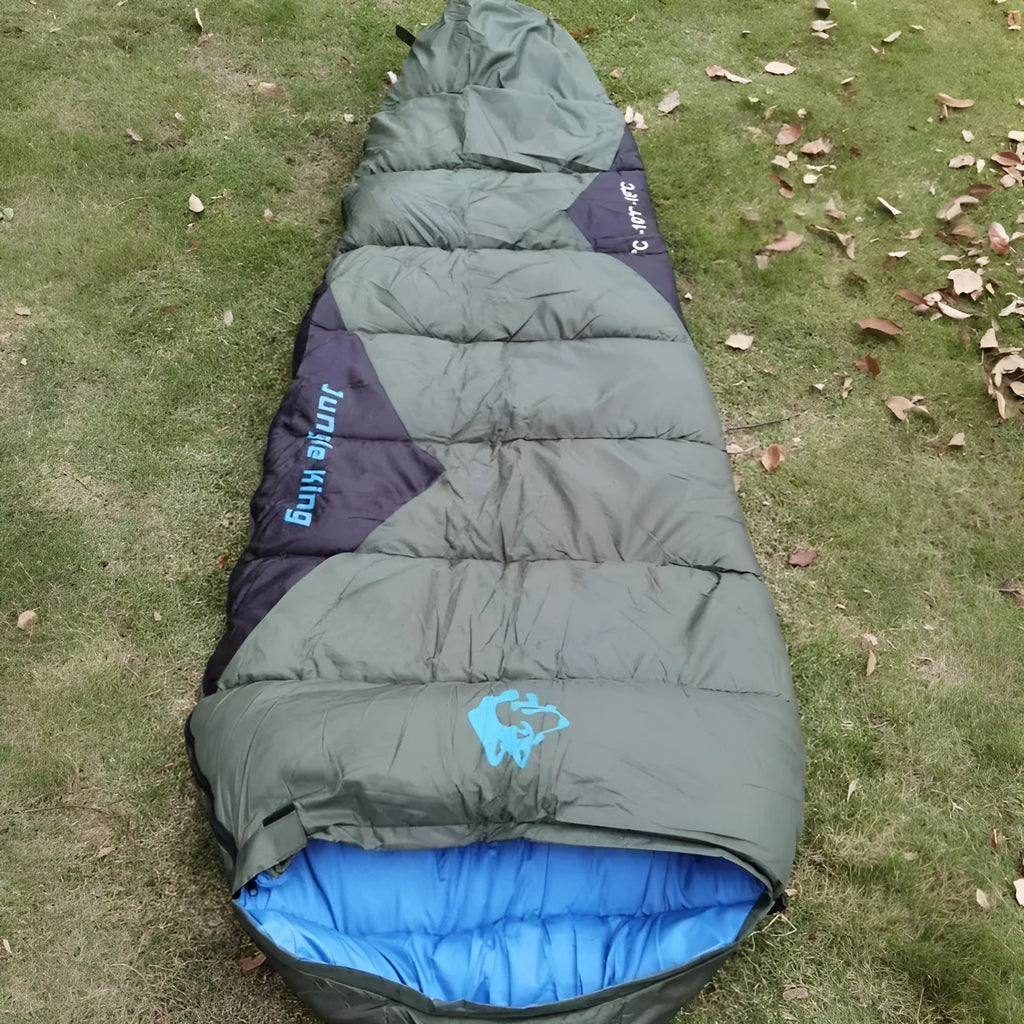 Cotton sleeping bag in Army Green colour compressed inside its storage bag alongside the unfolded sleeping bag.
