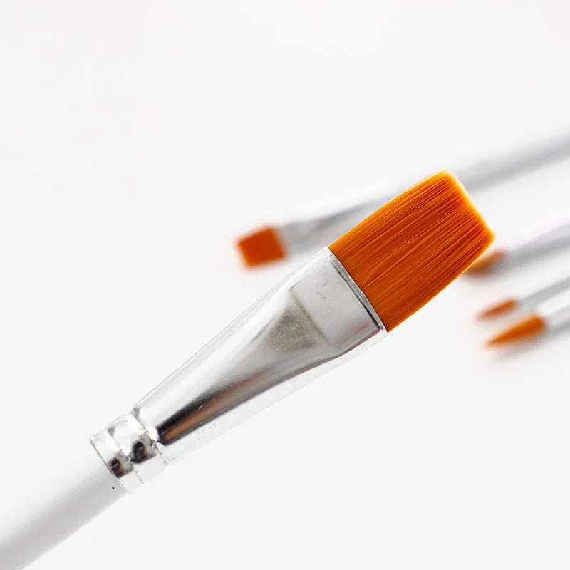 Set of six paint brushes with wooden handles and silver ferrules on a white background