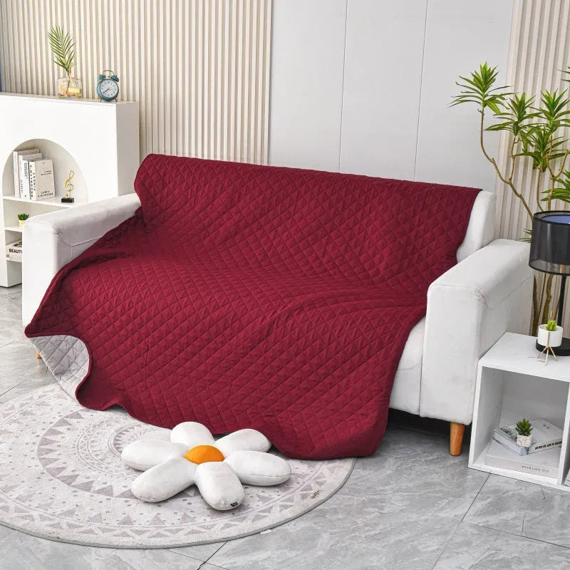 Reversible waterproof dog blanket couch cover in burgundy and grey, laid flat on a sofa.