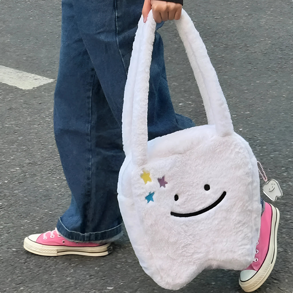 White plush large tooth shoulder tote bag with crossbody strap and zip closure.