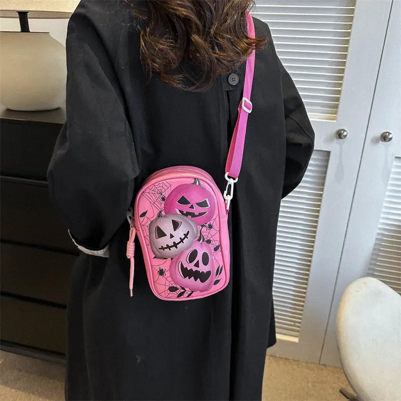 Black mini crossbody bag with Halloween cartoon print of pumpkins, ghosts, and bats.