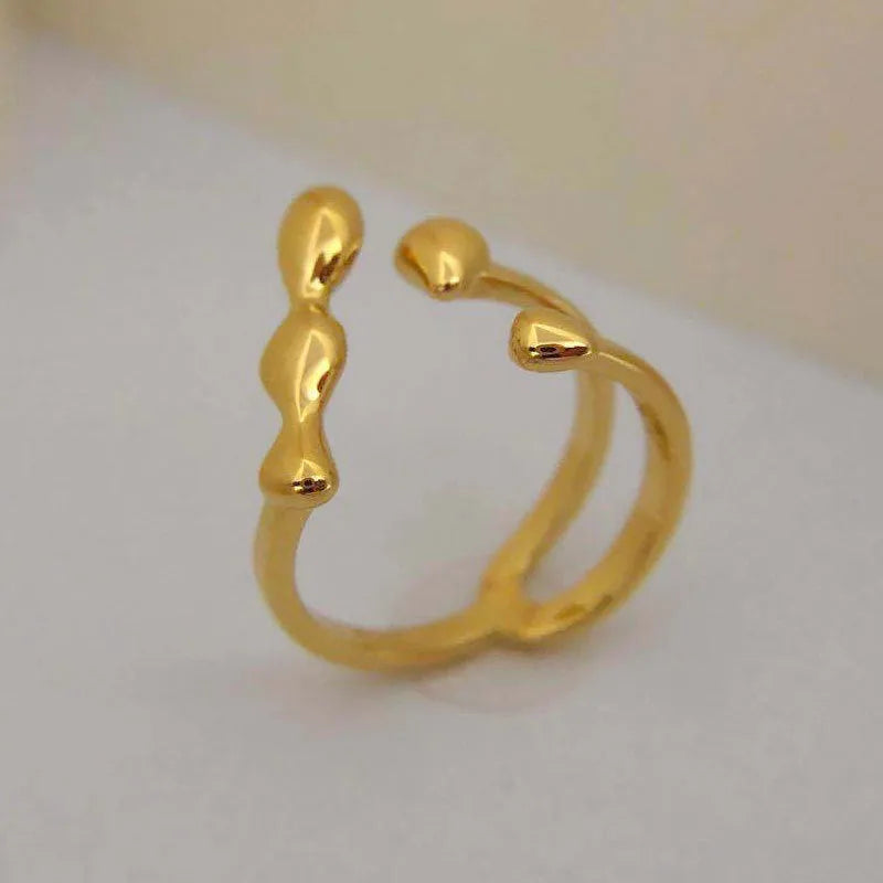 Brass opening ring in gold or silver finish with spherical design details.