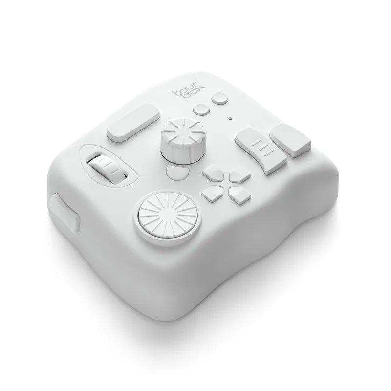 TourBox NEO black USB video editing controller auxiliary keyboard on a desk.