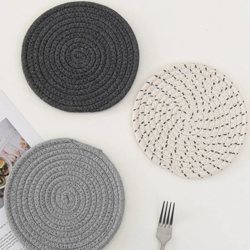 Set of three round cotton cord coasters in a choice of colours on a wooden table
