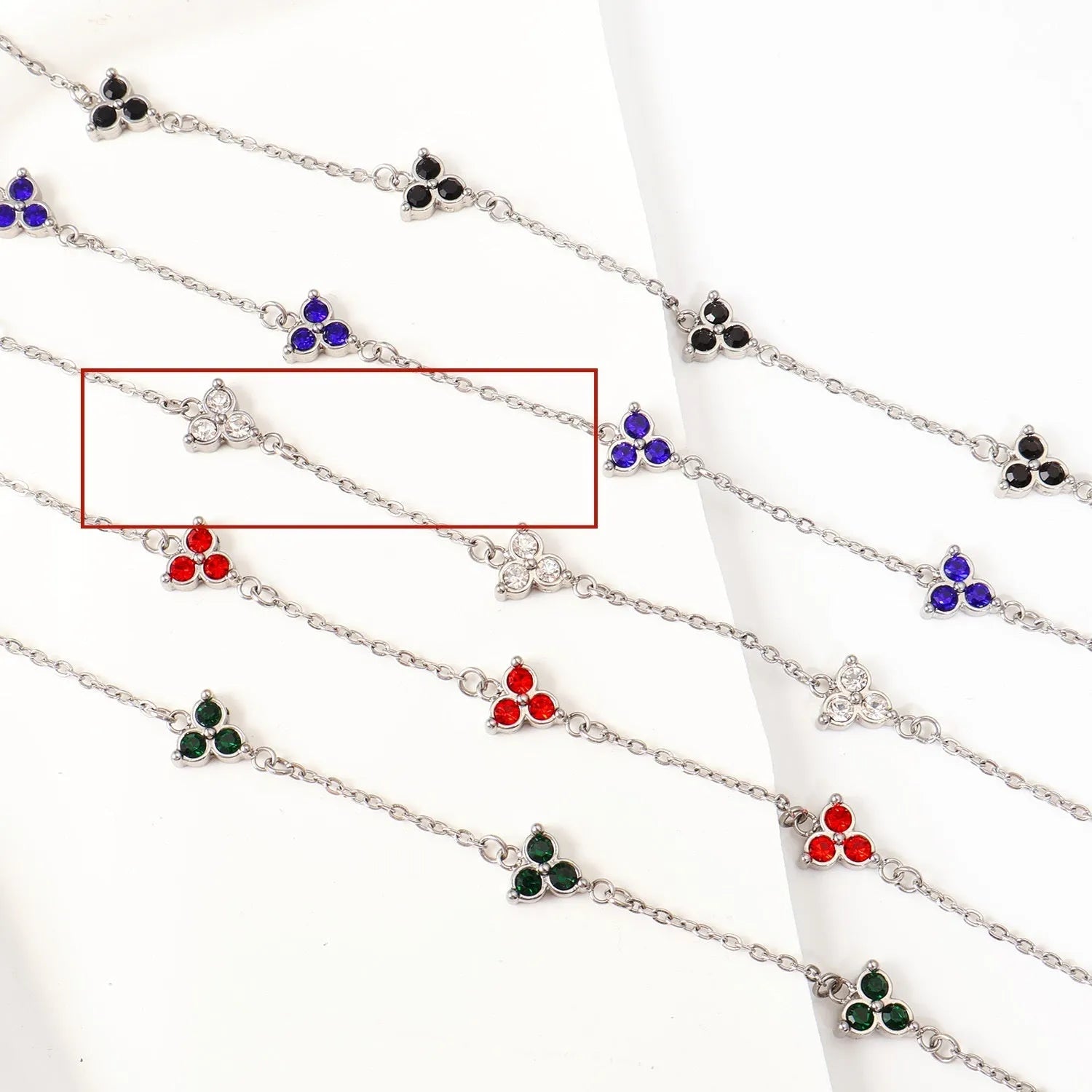 Geometric stainless steel women's bracelet with triangular links and a coloured stone centre.