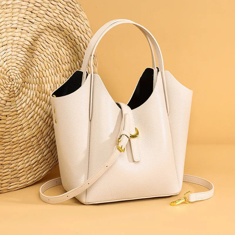 Genuine leather retro bucket handbag for women in beige, showing sewn thread detail and handheld straps.