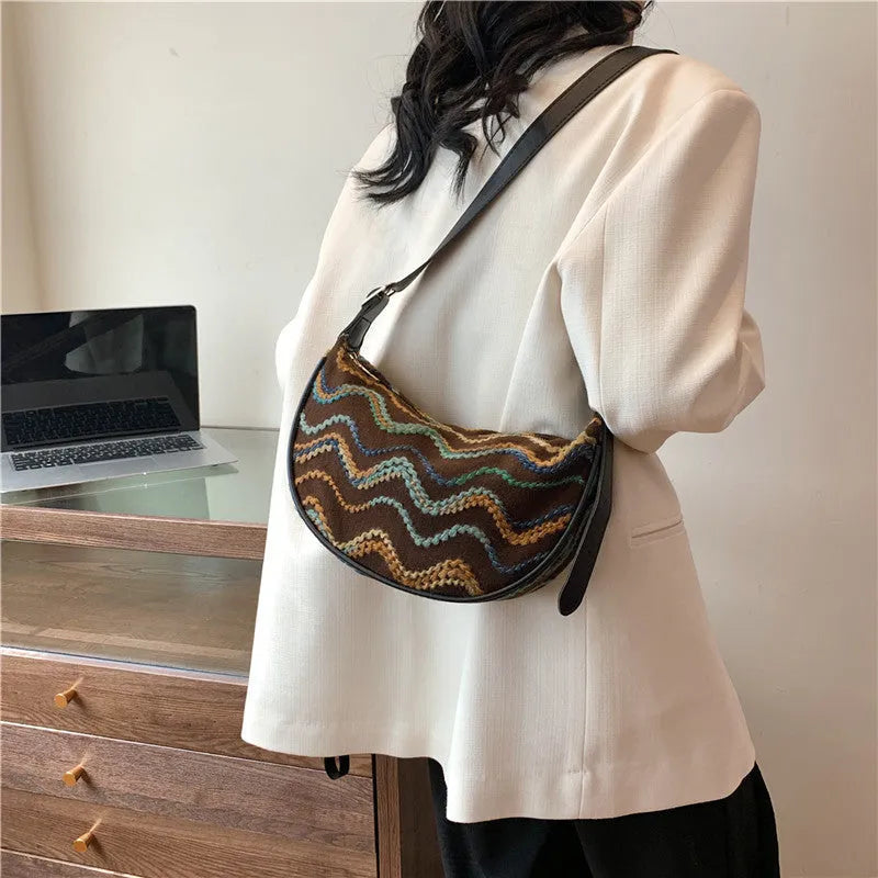 Women's straw woven crossbody bag showing woven texture and internal phone pocket