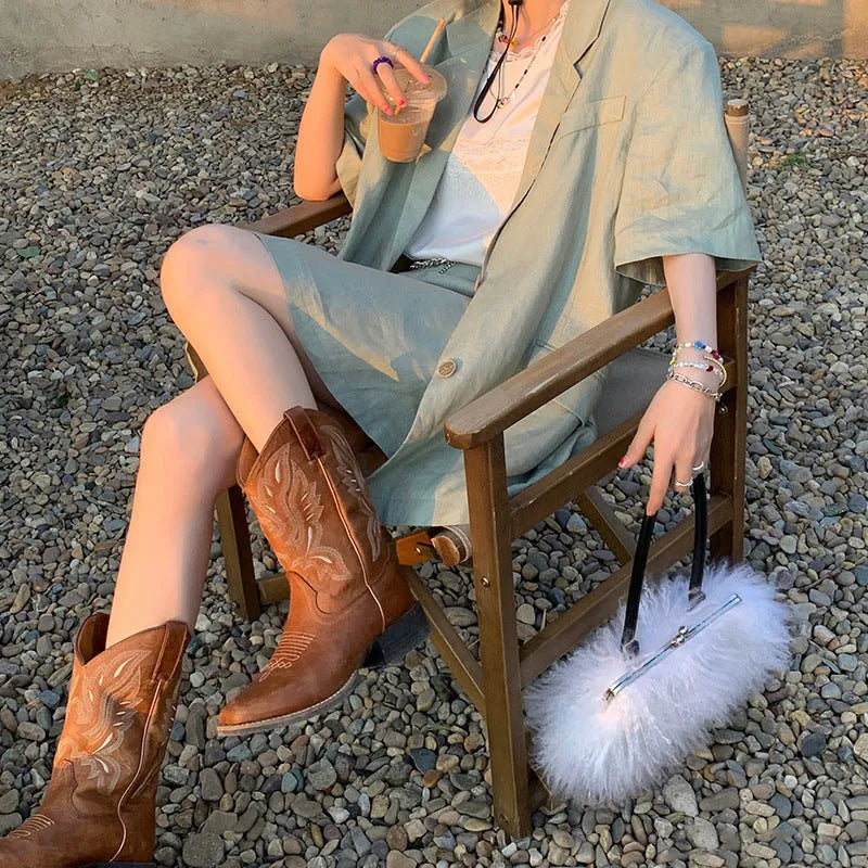 Brown women's mid-calf embroidered Martin boots with a leather lining and low rubber heel.