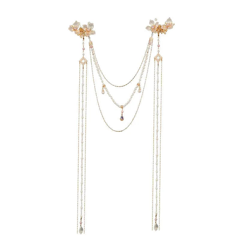 Close-up of a women's floral hairpin with white pearl, clear diamond accents, and a long gold tassel.
