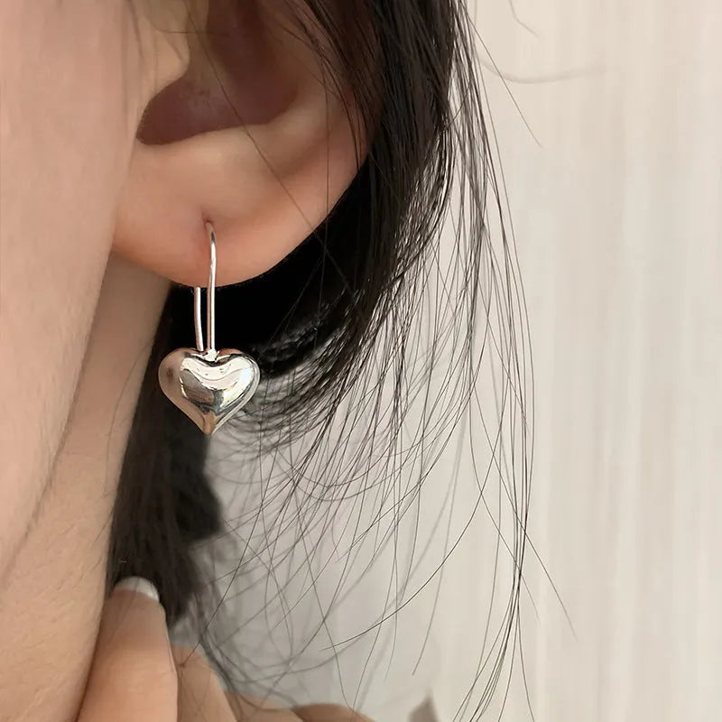 Korean style silver-coloured heart earrings with three-dimensional glossy finish and matching heart-shaped ear hooks