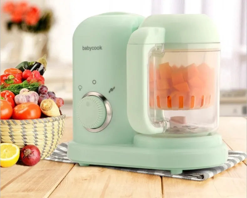 Green and pink baby food processor with steamer and blender functions, showing double mixing blades.