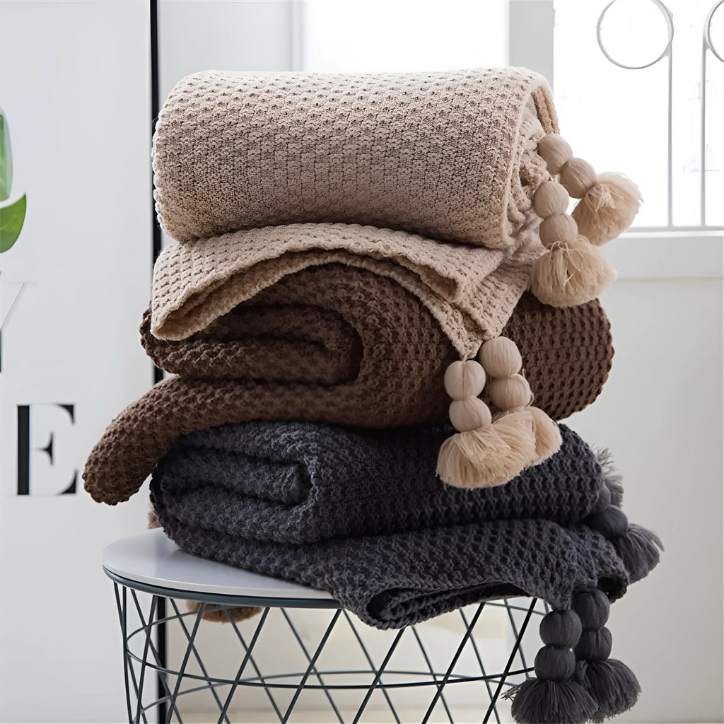 Nordic fringed knit acrylic blanket in beige colour draped over office chair