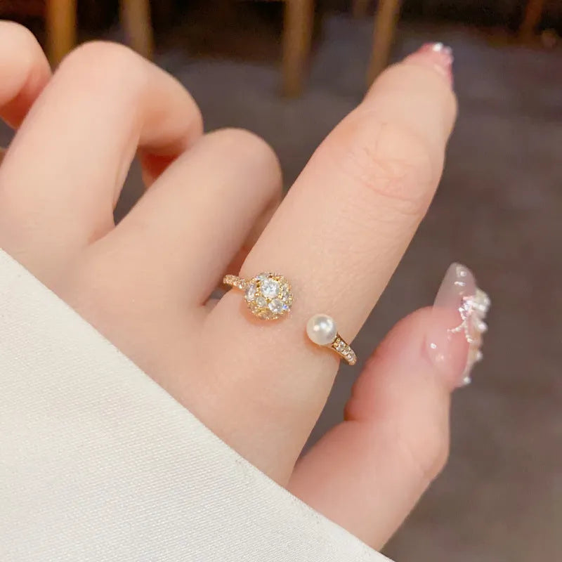 Women's open-end ring with round zircon and pearl detail in gold or silver finish