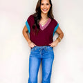 Burgundy loose-fit V-neck sweater with contrast trim on cuffed short sleeves.