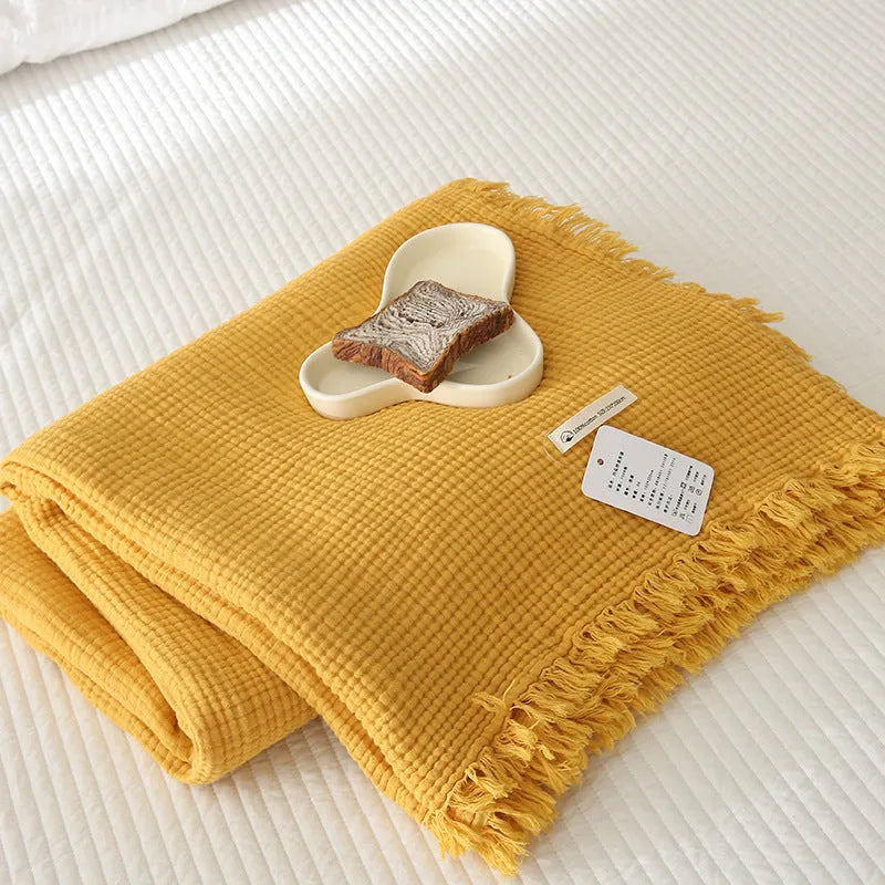 Four-layer gauze cotton blanket with tassel trim in a choice of ten colours and two sizes.