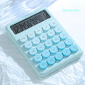 Gradient colour desk calculator in violet, cherry blossom pink, glacier blue, and mint green on a white desk.