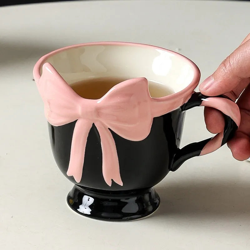 Ceramic mug with a decorative heart bow design in black pink or white powder colour.