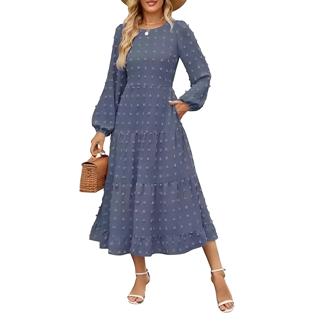 A woman wearing a beige high waist long sleeve dress with ruffled sleeves, a round neck, and a solid colour design.