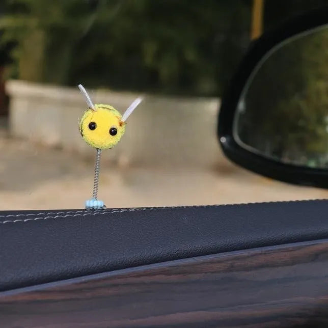 Small yellow and black fur ball bee car ornament with adhesive backing.