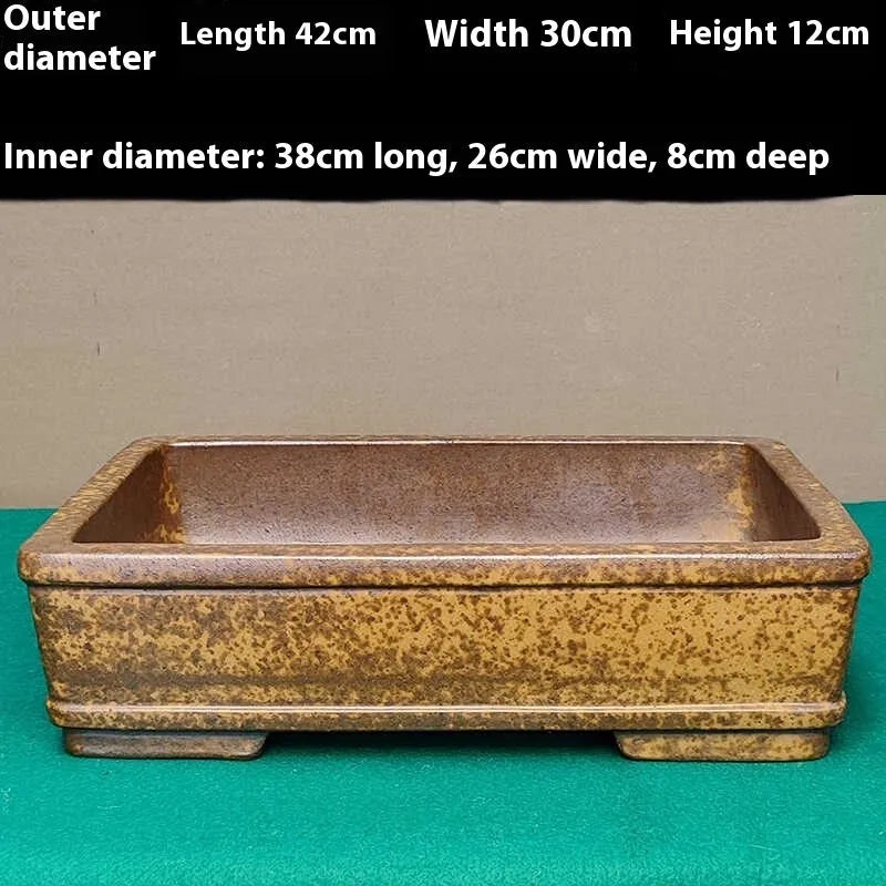 Straight shallow rectangular Yixing Zisha flowerpot in purple sand clay on a plain surface.