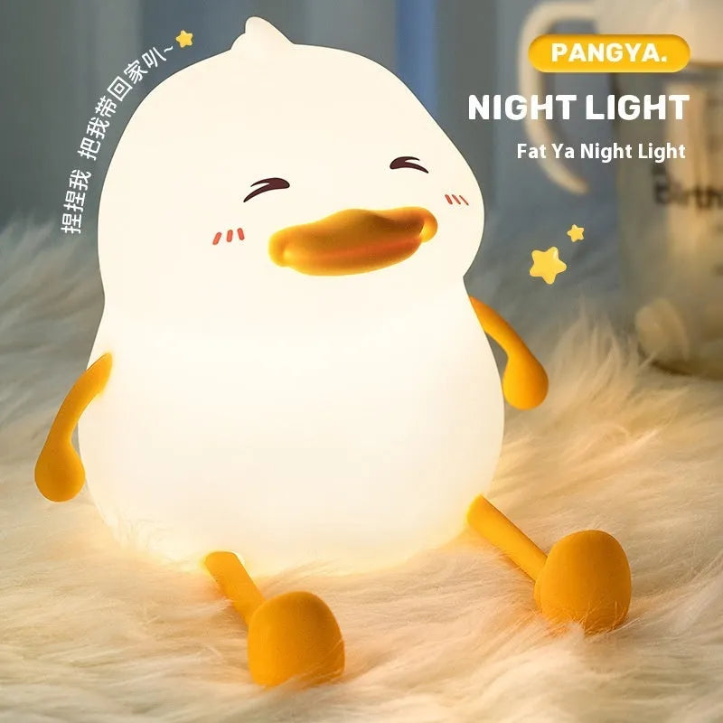 Chubby small night lamp with silicone pat design and integrated phone holder on desk
