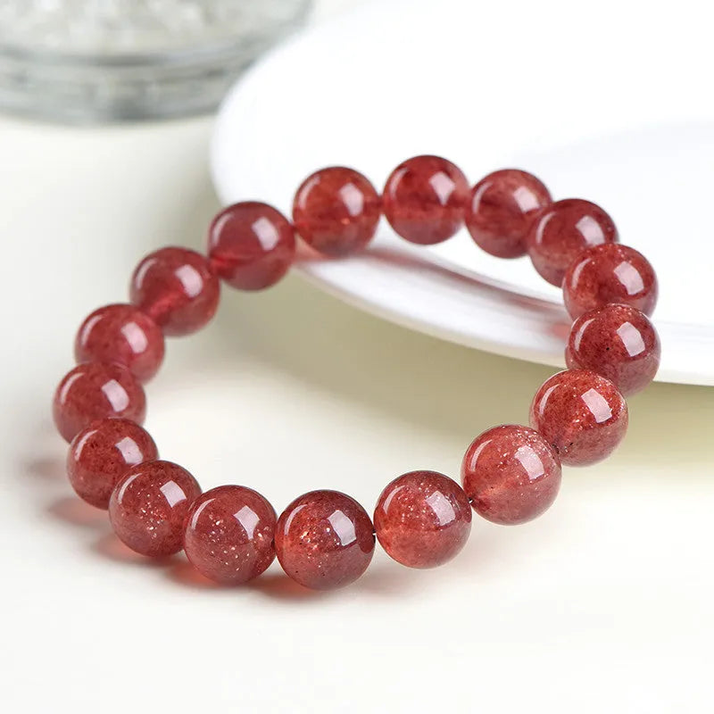 Natural cherry red strawberry quartz bracelet with geometry-shaped beads on a wrist.