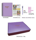 J12 Purple coil-bound monthly financial planning notebook with pen, stickers, and paper clips on a desk.