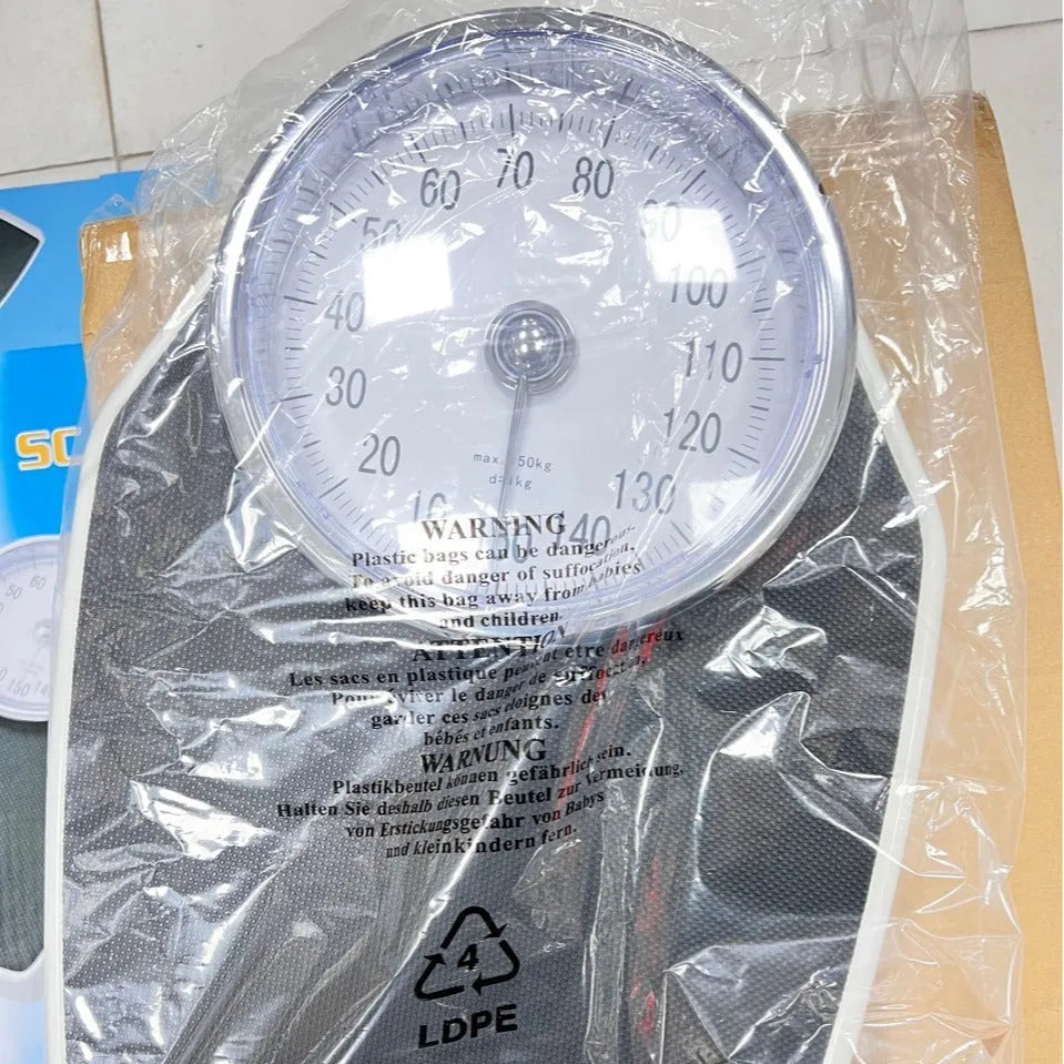 Black mechanical pointer body weight scale with large dial on a simple platform.