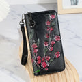 Embossed floral handbag with hand-painted details and a brass zipper in a retro style.