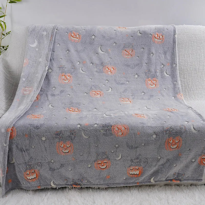 Cartoon print flannel blanket for children shown in two sizes on a bed.