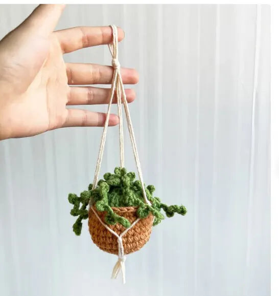 Green and white fish-scale style knitted wool car hanging planter with 8cm base and long white cord.